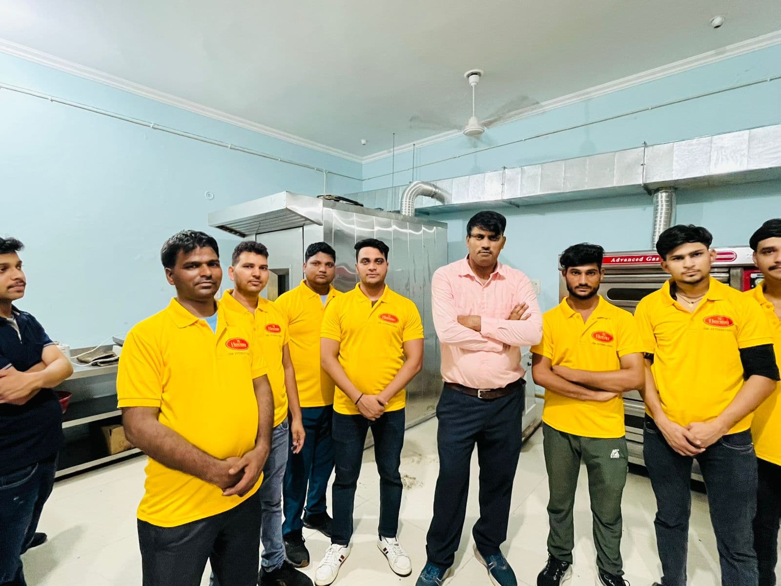 JBR bakery staff in yellow uniforms with a manager in the production facility