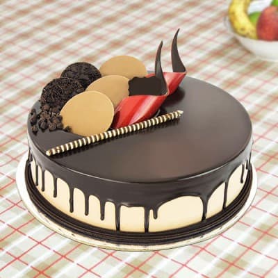 Chocolate cake with dark chocolate ganache drip, chocolate curls and fresh strawberry garnish