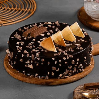 Chocolate cake with roasted almond crumb coating and white chocolate triangle garnish