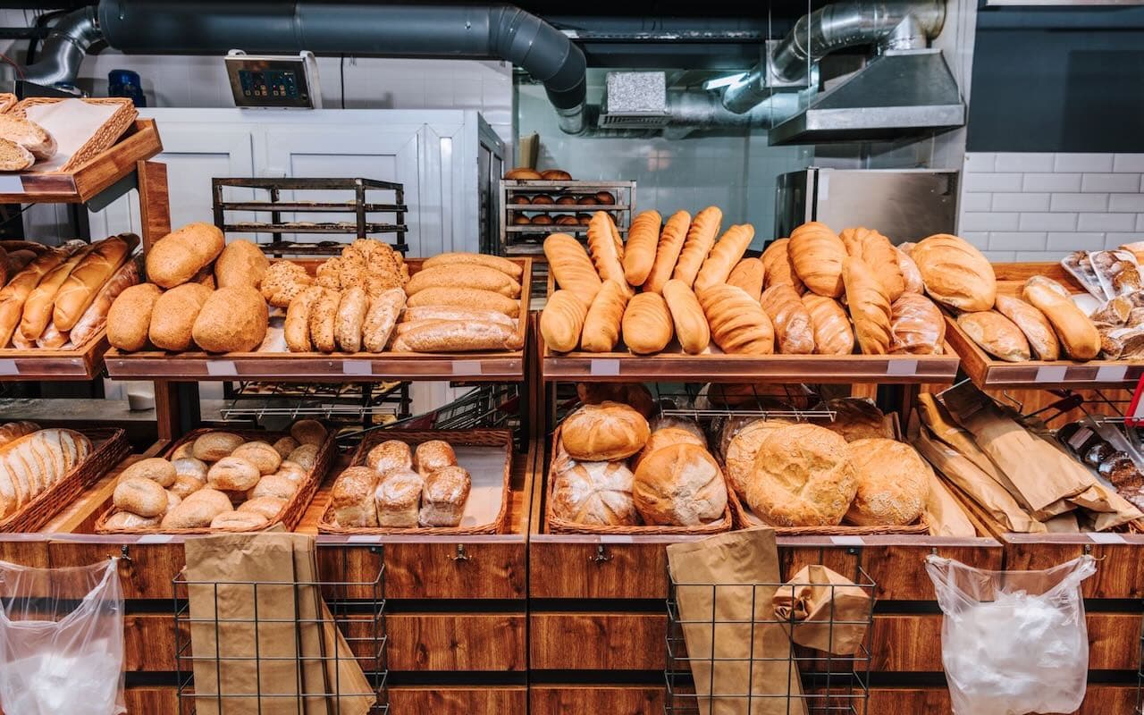 Fresh bulk bread loaves and buns racked at a Gurgaon bakery production facility